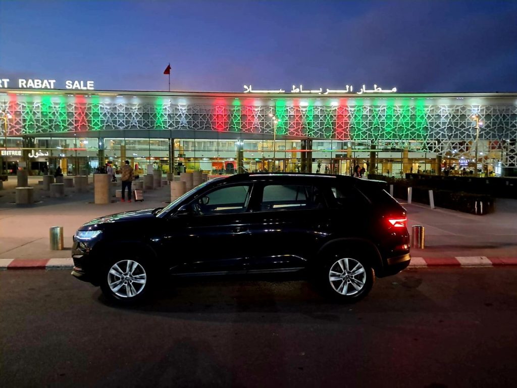 Voiture devant l'aéroport illuminé